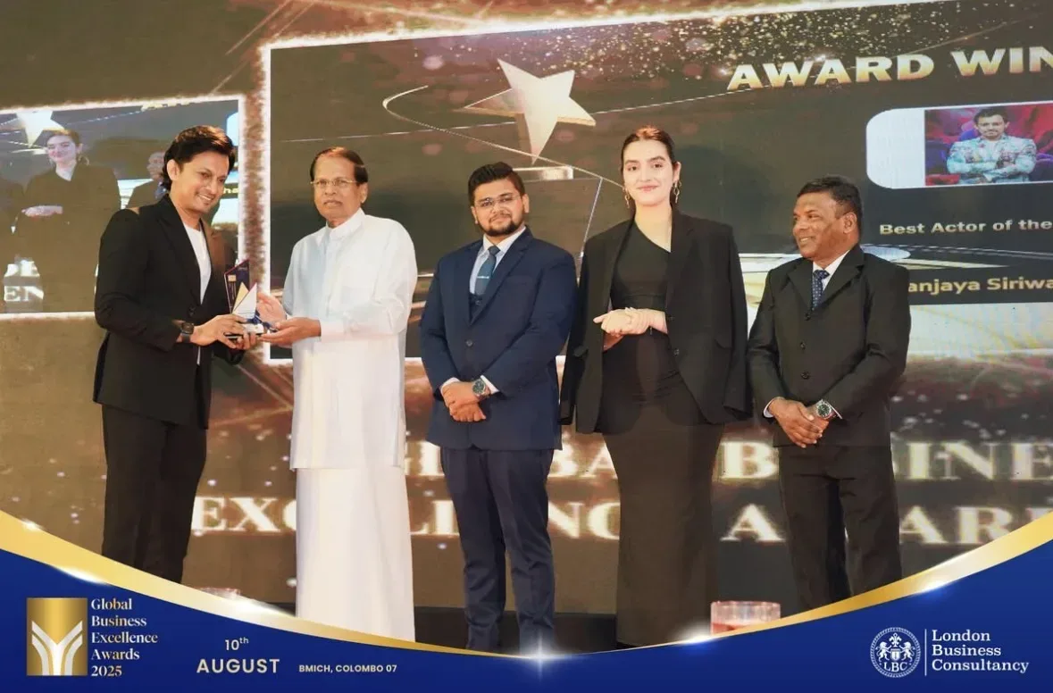 A recipient accepting a Global Business Excellence Award on stage