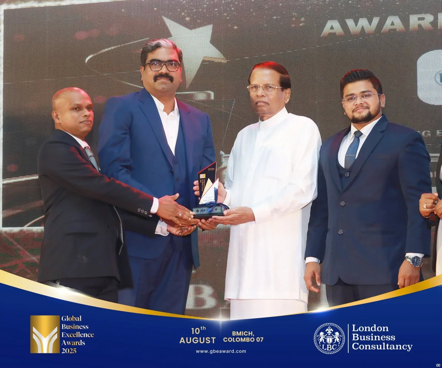 Global Business Excellence Awards recipient receiving a trophy on stage