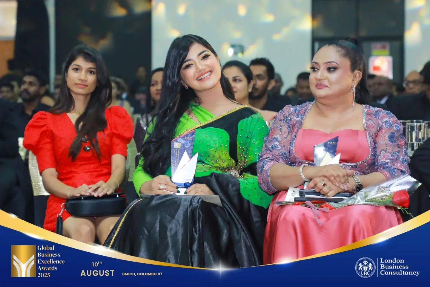 Global Business Excellence Awards recipients seated together with trophies