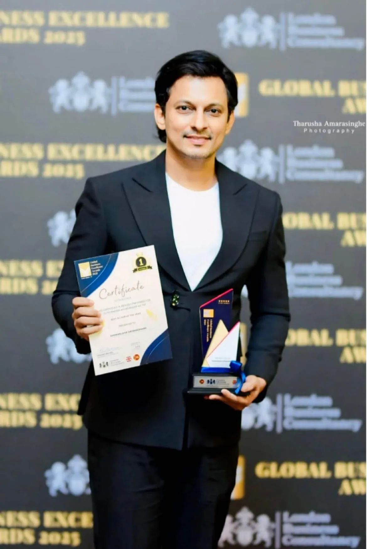 Global Business Excellence Awards recipient displaying a trophy and certificate