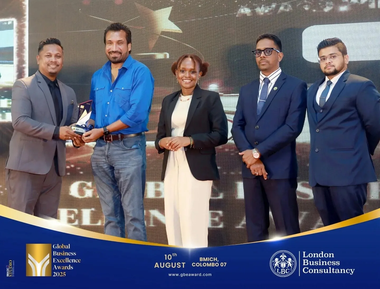Global Business Excellence Awards recipient and representatives during a stage presentation