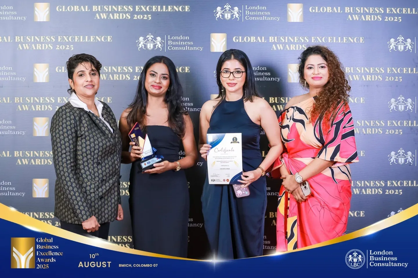 Global Business Excellence Awards recipient and guests holding an award and certificate