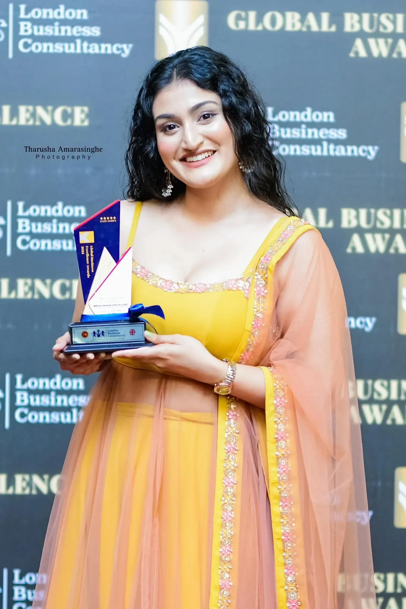 Global Business Excellence Awards recipient holding a presentation trophy