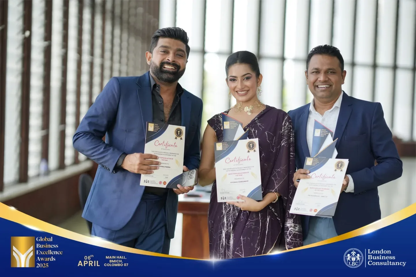 Three Global Business Excellence Awards recipients holding trophies and certificates