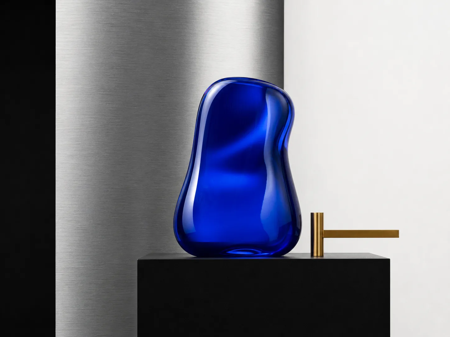 Sculptural blue glass form in a precise campaign still life